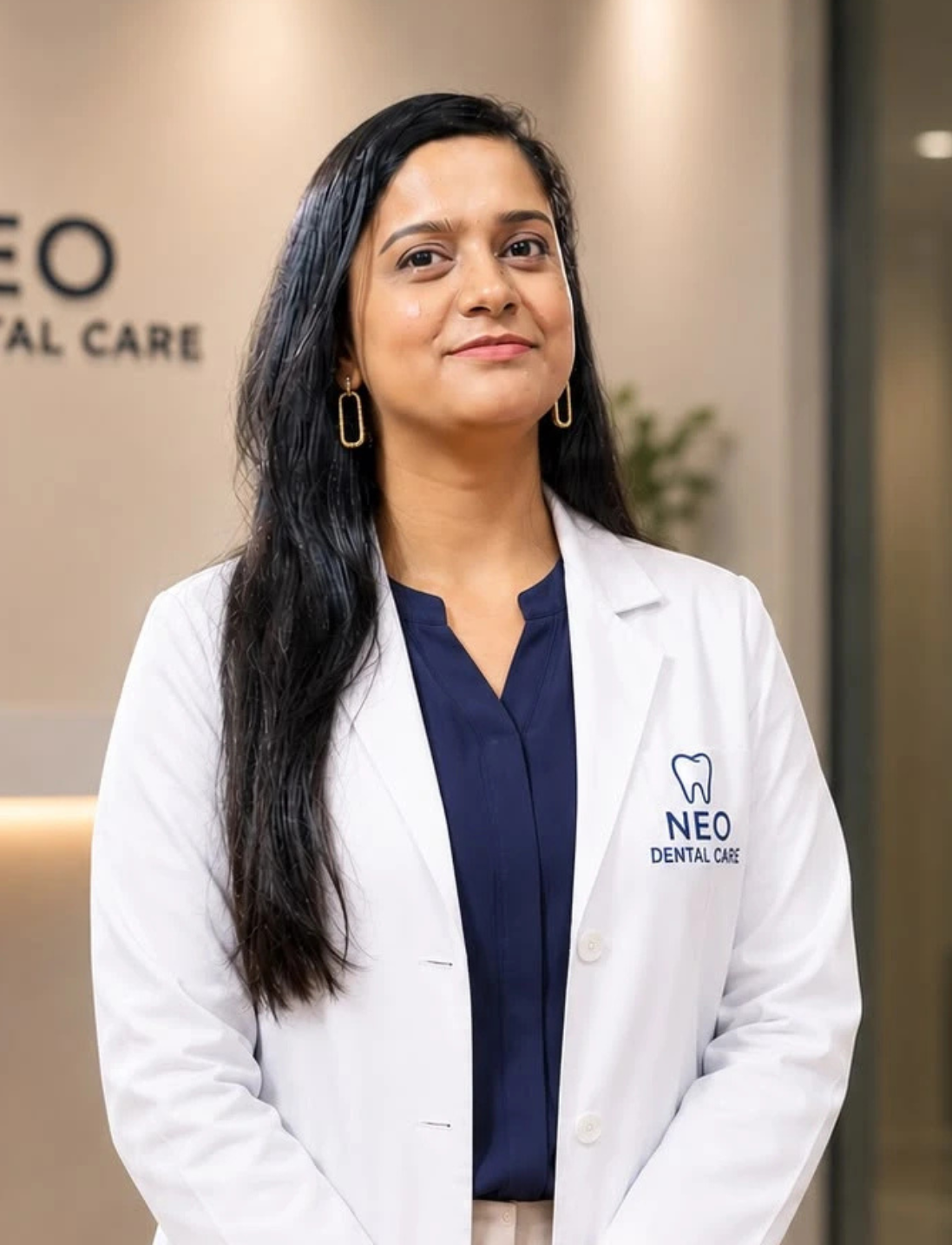 1 | Neo Dental | Neo Dental Female dentist in a white coat with a navy blouse, standing in a clinic near the Neo Dental Care sign.